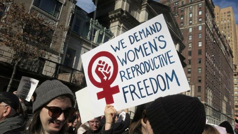 Sign held up in a protest reading: We demand Women's Reproductive Freedom